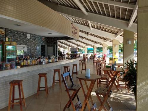 a bar with chairs and tables in a restaurant at Enseada Náutico Apart Flat Quinto Andar in Caldas Novas