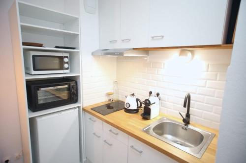 een kleine keuken met een wastafel en een magnetron bij Charmant studio avec terrasse, refait à neuf in Aix-en-Provence