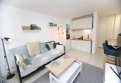 een woonkamer met een bank en een tafel bij Charmant studio avec terrasse, refait à neuf in Aix-en-Provence