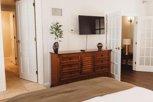 a bedroom with a dresser with a tv on the wall at The Jefferson Inn in Southern Pines