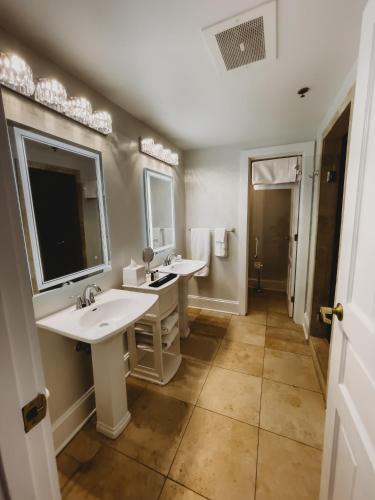 a bathroom with two sinks and a large mirror at The Jefferson Inn in Southern Pines