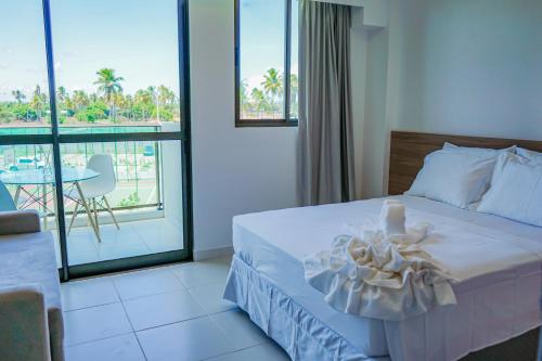 um quarto de hotel com uma cama e uma varanda em Mana Beach Experience By Mai em Porto de Galinhas