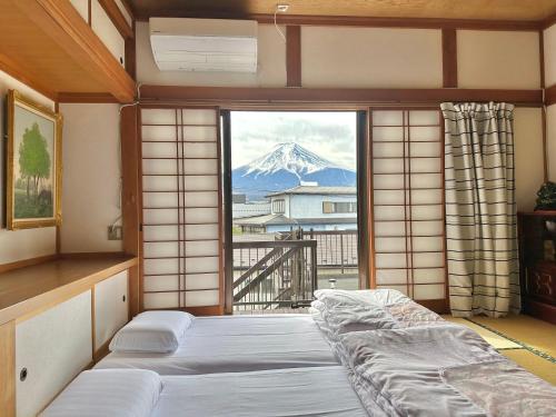 sypialnia z widokiem na pokrytą śniegiem górę w obiekcie Guest house En w mieście Fujiyoshida
