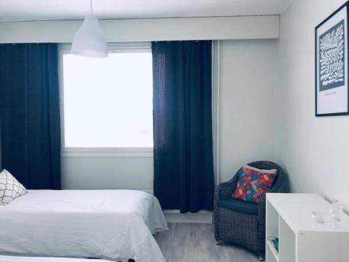 ポリにあるKotimaailma Pori asunto 3 henkilölleのベッド2台と椅子と窓のある寝室