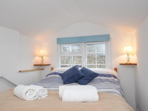 a bedroom with a bed with towels on it at Mole Cottage in Liskeard