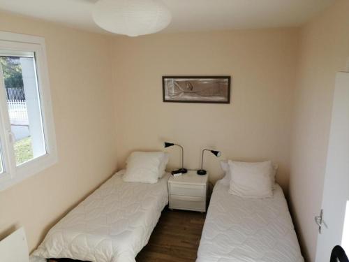2 łóżka w pokoju z białymi ścianami w obiekcie Villa ROYAT w mieście Royat