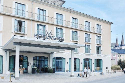 a large white building with a sign on it at Hotel EDELWEISS Berchtesgaden Superior in Berchtesgaden