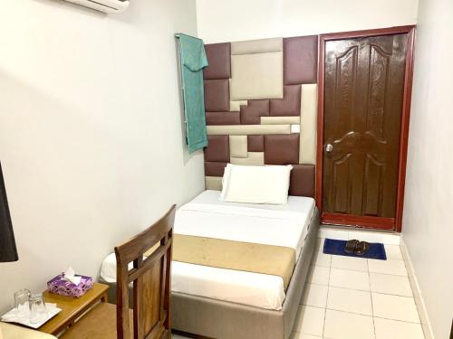 a small room with two beds and a door at Star Guest House in Karachi