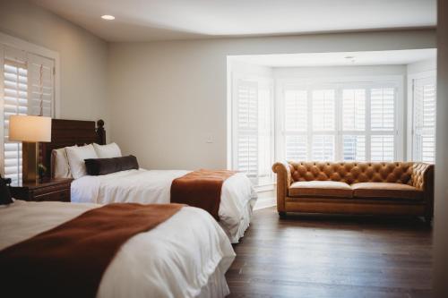 a hotel room with two beds and a couch at The Jefferson Inn in Southern Pines