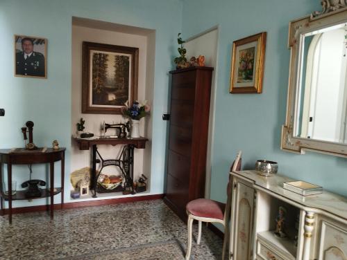 een kamer met blauwe muren, een stoel en een kast bij Casa Orisca in Lesa