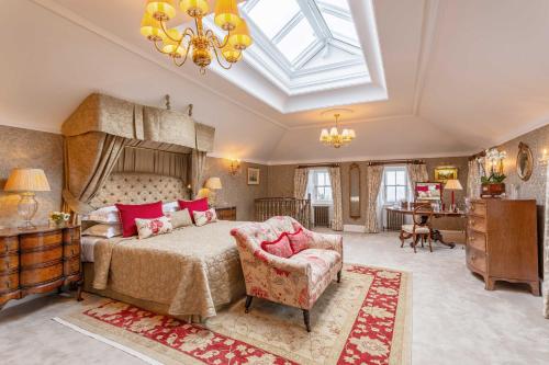a bedroom with a bed and a chair and a skylight at Glenapp Castle in Ballantrae