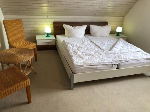 a bedroom with a bed and a chair and a table at Nehmzowsgang 13 in Zingst