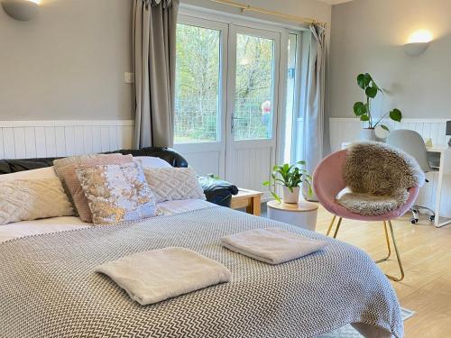 a bedroom with a bed with a chair and a window at Homestead Cottage, Fort Augustus in Fort Augustus