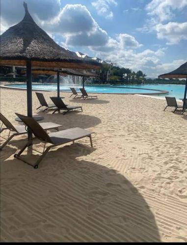 a group of chairs and umbrellas on a beach at Home away from home in Avondzon