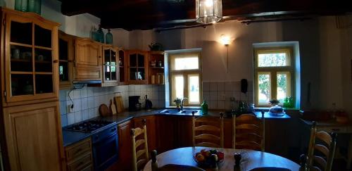 a kitchen with wooden cabinets and a table in it at Patak Üdülőház (Ferienhaus) in Nagyvisnyó