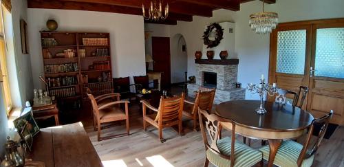 comedor con mesa, sillas y chimenea en Patak Üdülőház (Ferienhaus), en Nagyvisnyó