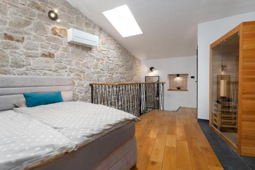a bedroom with a bed and a stone wall at Apartments Casanova in Vrsar