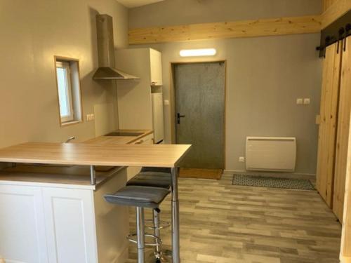 kuchnia z blatem i stołkami w pokoju w obiekcie Agréable studio proche de Rouen w mieście Le Grand-Quevilly