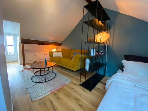 un salon avec un canapé jaune et une table dans l'établissement Le Loft Lepic, à Paris