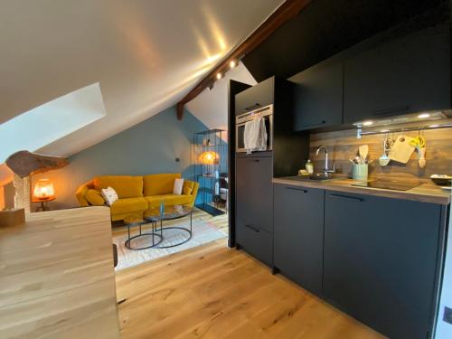 Il comprend une cuisine et un salon avec un canapé jaune. dans l'établissement Le Loft Lepic, à Paris