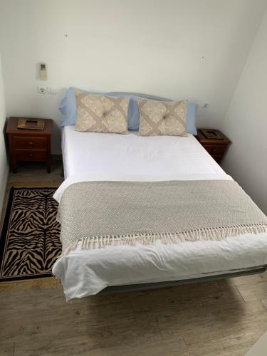 a bedroom with a large bed with white sheets and pillows at Chalet Jamaica 2 in Peñíscola