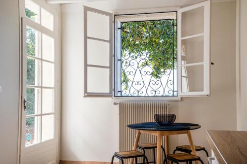 kuchnia ze stołem i krzesłami pod oknem w obiekcie Maison au coeur du vignoble de Saint-Emilion w mieście Saint-Étienne-de-Lisse