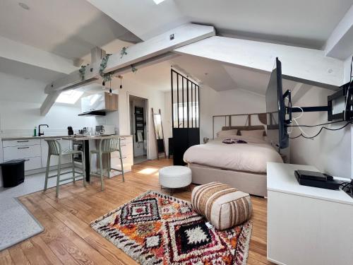 une chambre avec un lit et une cuisine avec une table dans l'établissement Superbe studio plein de charme proche du centre Tonnet, à Clermont-Ferrand