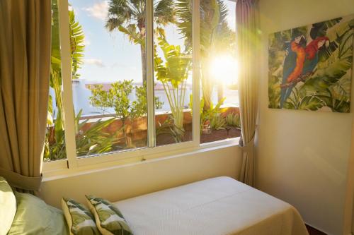 a bedroom with a window with a view of a bird at In the garden in Adeje