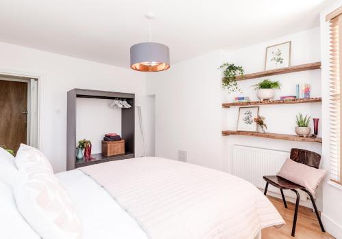 a white bedroom with a bed and a chair at Near Notting Hill 2 bed Spacious apartment Queens Park Nw6 - QPARK in London