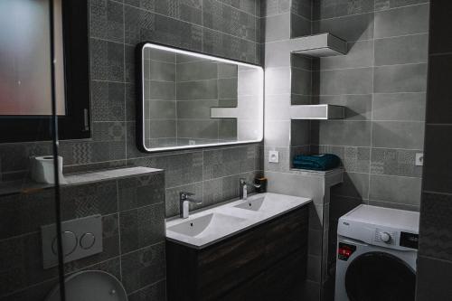 La salle de bains est pourvue d'un lavabo et d'un miroir. dans l'établissement Grande Villa cosy avec piscine, sauna & jacuzzi, à Juvignac