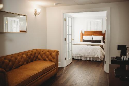 a living room with a couch and a bed at The Jefferson Inn in Southern Pines