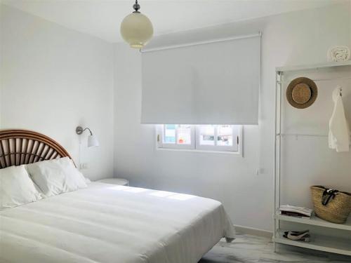 ein weißes Schlafzimmer mit einem Bett und einem Fenster in der Unterkunft Casa Eloína in Playa Honda