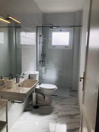 a bathroom with a sink and a toilet and a window at Casa Eloína in Playa Honda