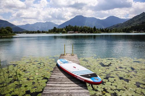a boat sitting on a dock on a lake at Spa & Resort Bachmair Weissach, LUXURY FAMILY RESORT in Rottach-Egern