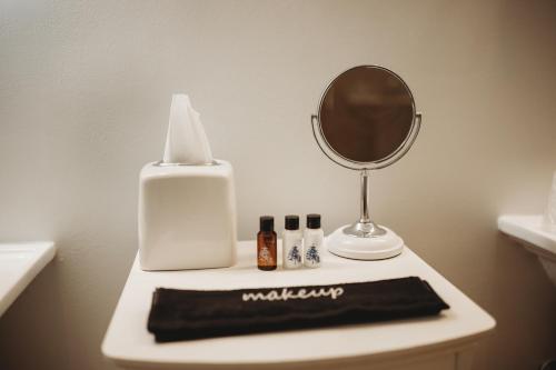 a bathroom with a mirror and a towel on a sink at The Jefferson Inn in Southern Pines
