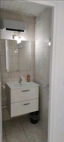 une salle de bain avec un lavabo et un miroir dans l'établissement Studio A au pied des Thermes de Néris-les-Bains, à Néris-les-Bains