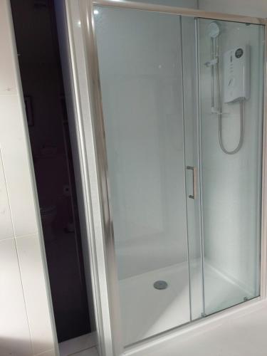 a shower stall with a glass door in a bathroom at The Causeway in Bracadale