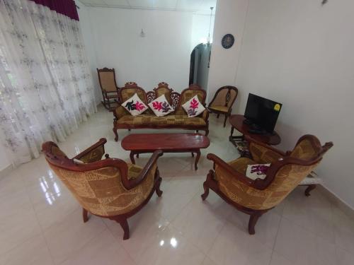 a living room with couches and chairs and a tv at Escape Ella Bungalow in Bandarawela