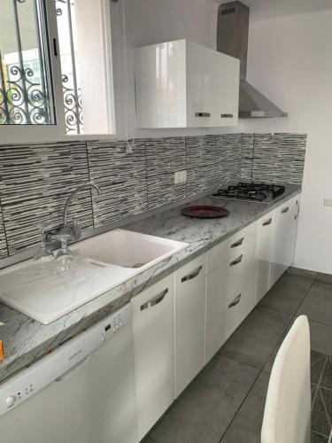 a white kitchen with a sink and a stove at Chalet Jamaica 2 in Peniscola