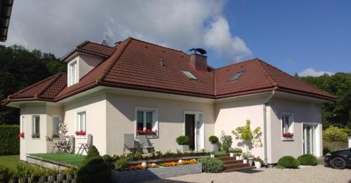 een wit huis met een rood dak bij Villa pod Szczeblem in Kasinka