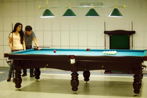 two people standing next to a pool table at Modern Hotel in Baku