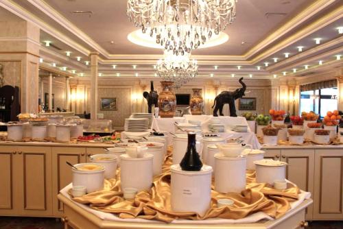 a table with white dishes and a chandelier at Modern Hotel in Baku