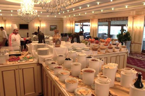 a buffet line with white cups and plates of food at Modern Hotel in Baku