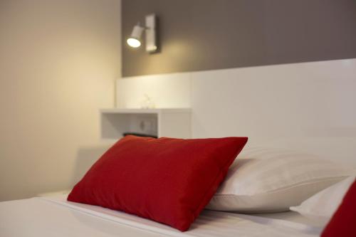 a red pillow sitting on top of a bed at Villa Nena in Makarska