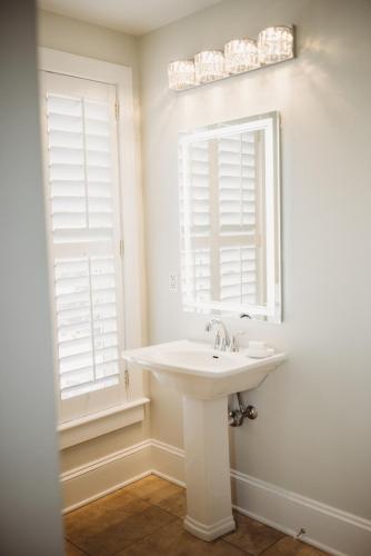 a bathroom with a sink and two windows at The Jefferson Inn in Southern Pines