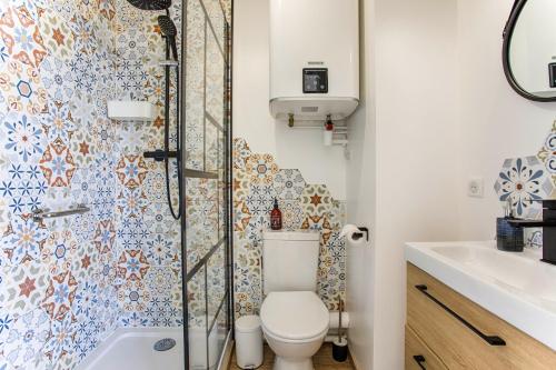 La salle de bains est pourvue d'une douche et de toilettes. dans l'établissement Appartement cosy avec vue imprenable sur Cabourg - accès direct plage - proche centre ville, à Cabourg