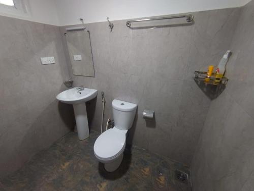 a bathroom with a toilet and a sink at Escape Ella Bungalow in Bandarawela