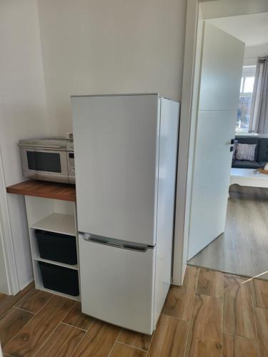 a white refrigerator in a kitchen with a microwave at Auf der Reuth in Selb
