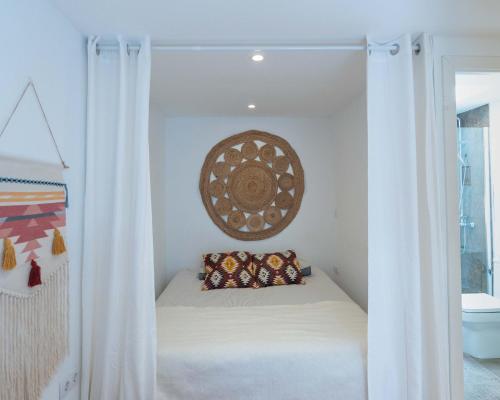 a bed in a room with white curtains at Tiny House By Casa Maui in Corralejo