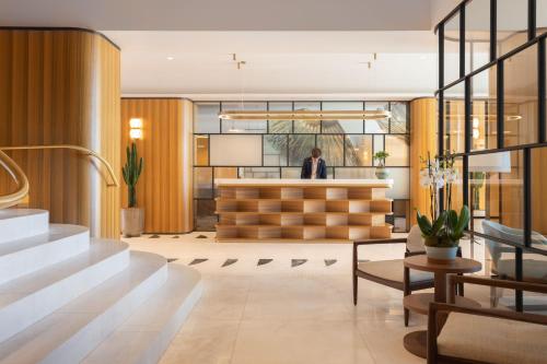 a man standing at a counter in a lobby at Mondrian Cannes in Cannes